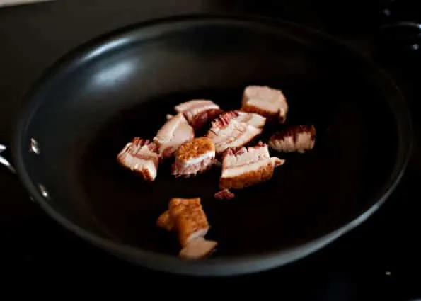 cooking pieces of bacon in a pan for blue cheese bacon dip