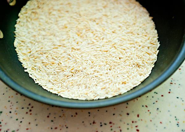 toasted rice in a pan for mediterranean rice salad