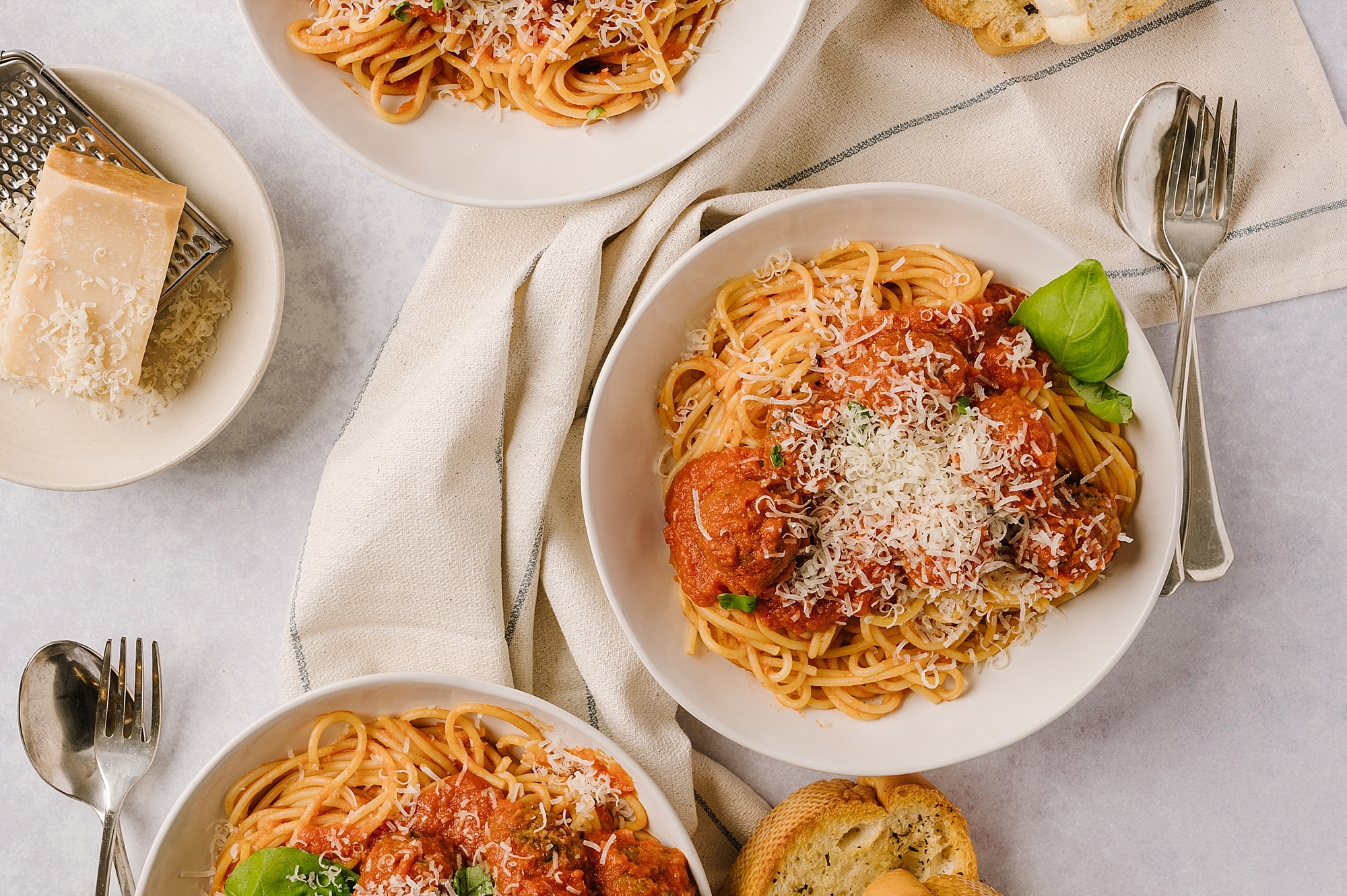 plates of spaghetti and meatballs with parmesan cheese