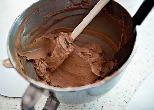 chocolate buttercream in a mixing bowl with a spatula