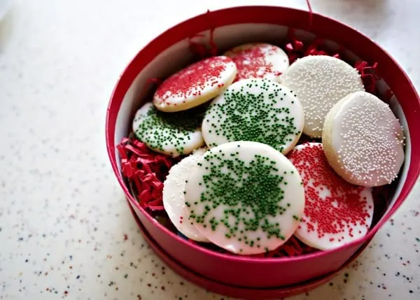 sugar cookies with sugar cookie glaze in a tin for gift giving