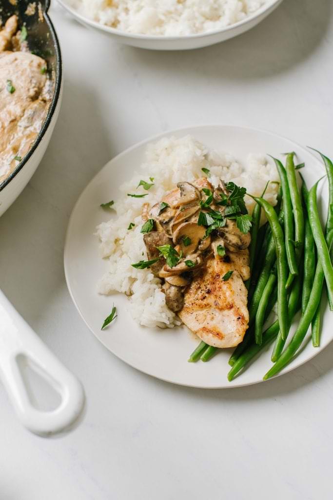 boursin chicken with rice and green beans on white plate