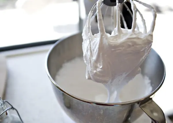 fluffy white icing in mixing bowl and on stand mixer attachment