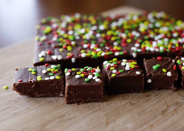 chocolate fudge topped with sprinkles sliced up on a cutting board