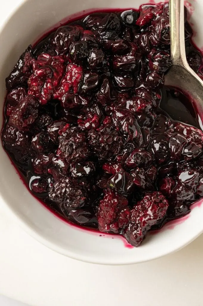 roasted summer berries in a bowl with a spoon
