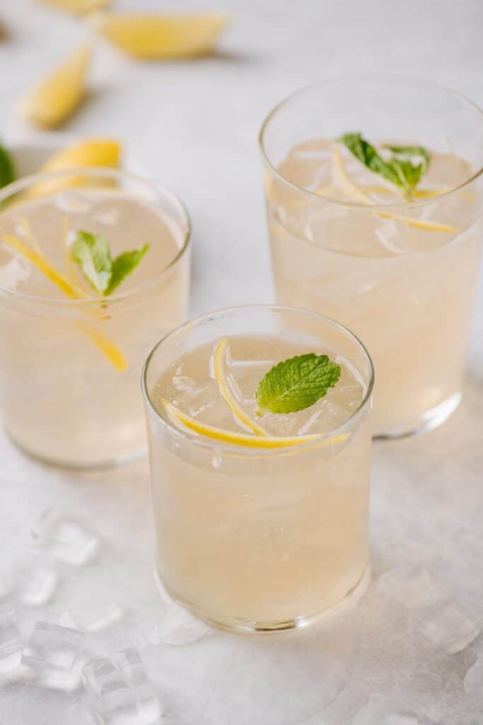 Elderflower smash cocktail with slices lemons in the background