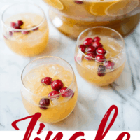 three glasses filled with jingle juice with punch bowl in background
