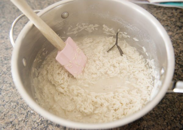 stirring almond milk into rice to make dairy free rice pudding