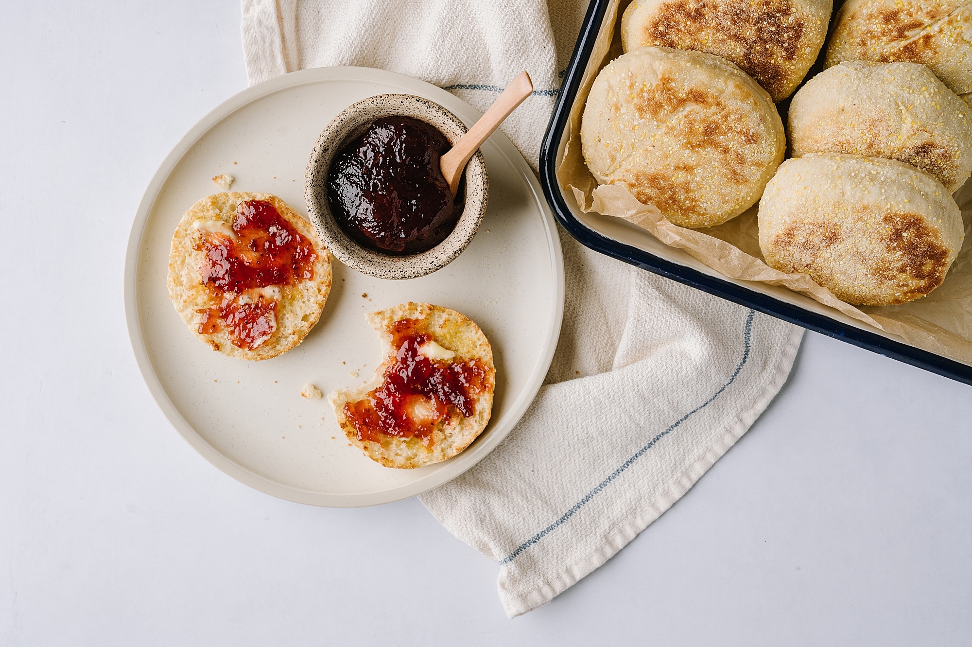 huckleberry english muffins on a plate with jam and dish of muffins in the background