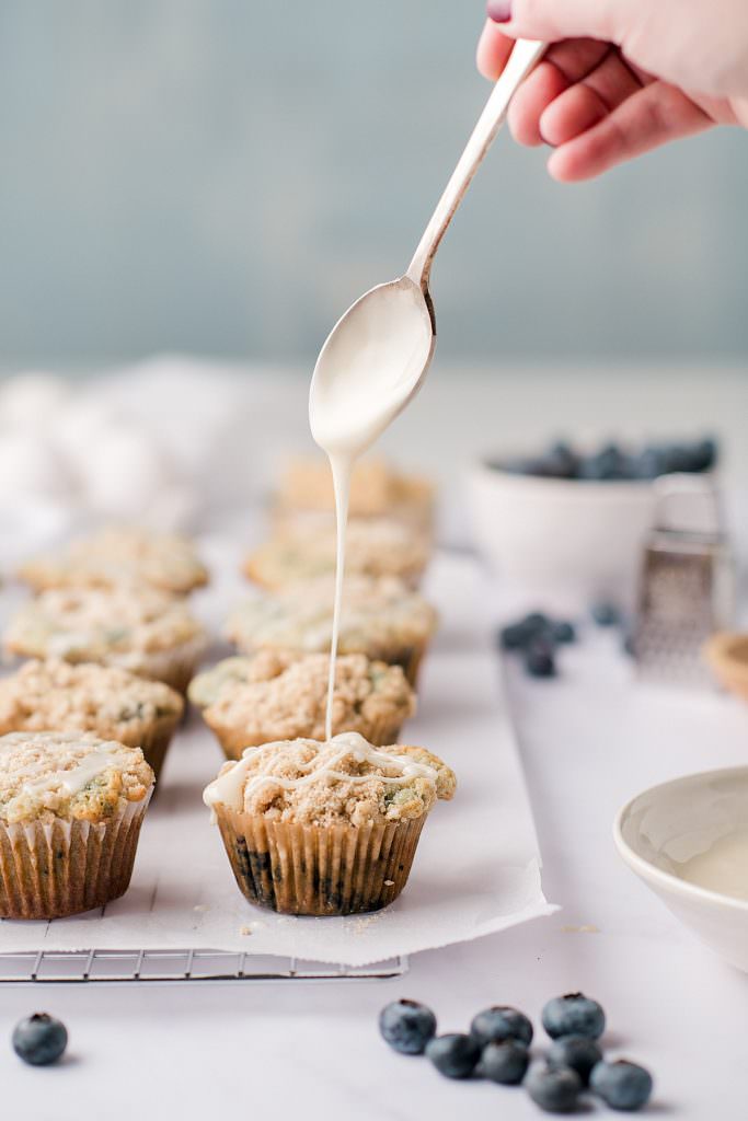 muffins with a spoon drizzling glaze