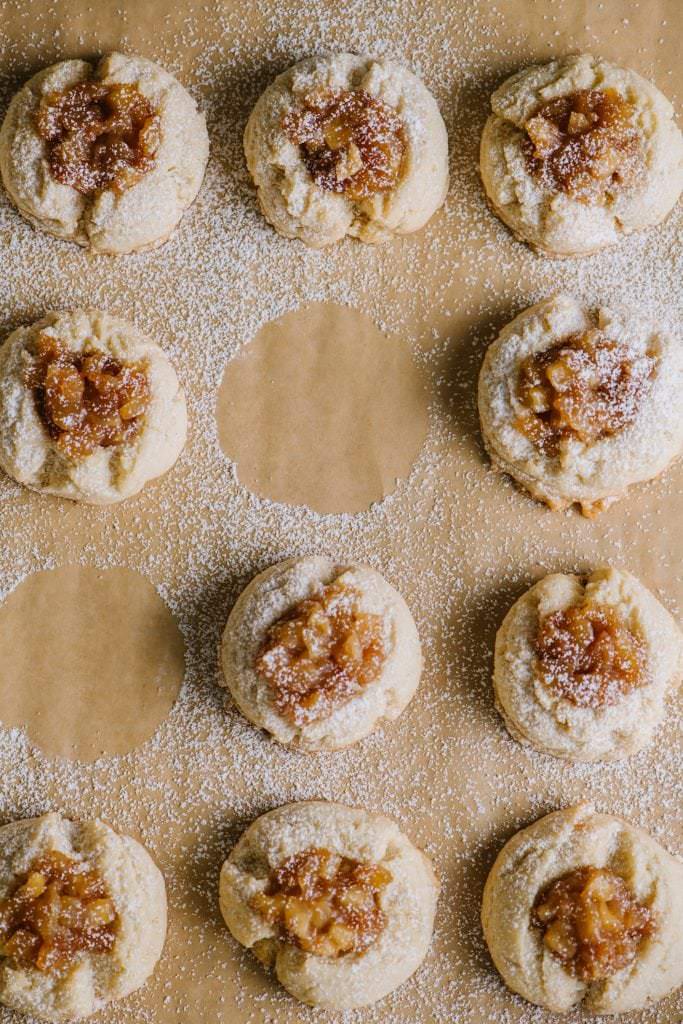 apple pie thumbprint cookies on a wooden sheet close up