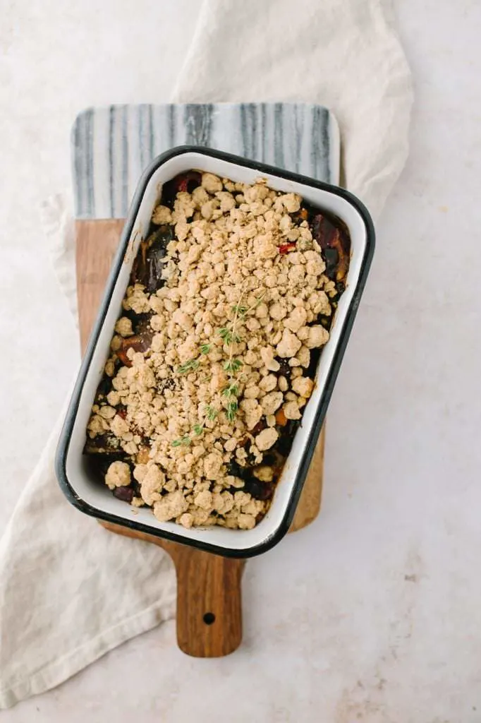 roasted vegetable crisp in a pan with a bowl and spoon