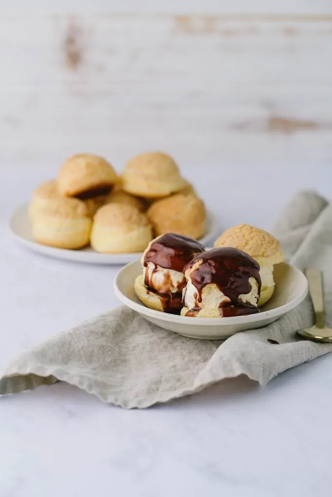 plate of cream puffs with chocolate sauce