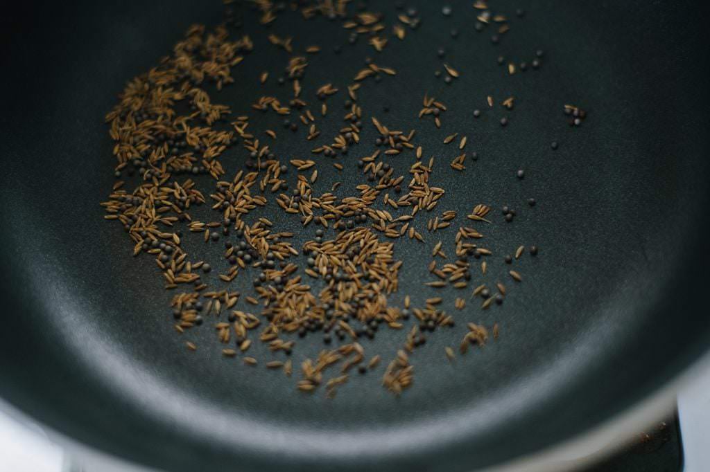 dry toasting cumin and mustard seeds in a pan