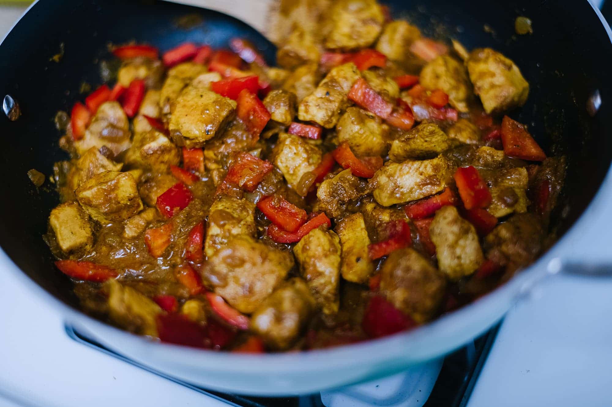 red peppers in chicken curry in pan