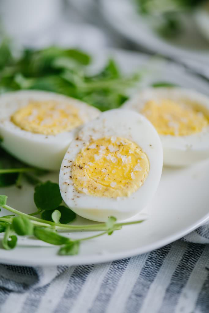 hard boiled eggs with microgreens on white plate
