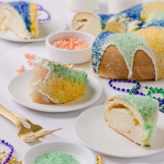 sliced Fat Tuesday cake on white plates with sprinkles