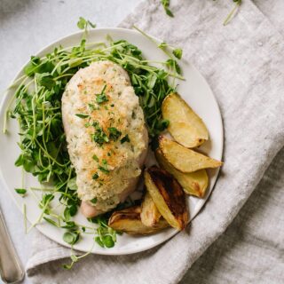 easy weeknight chicken breast with greens and potatoes on white plate with fork and knife