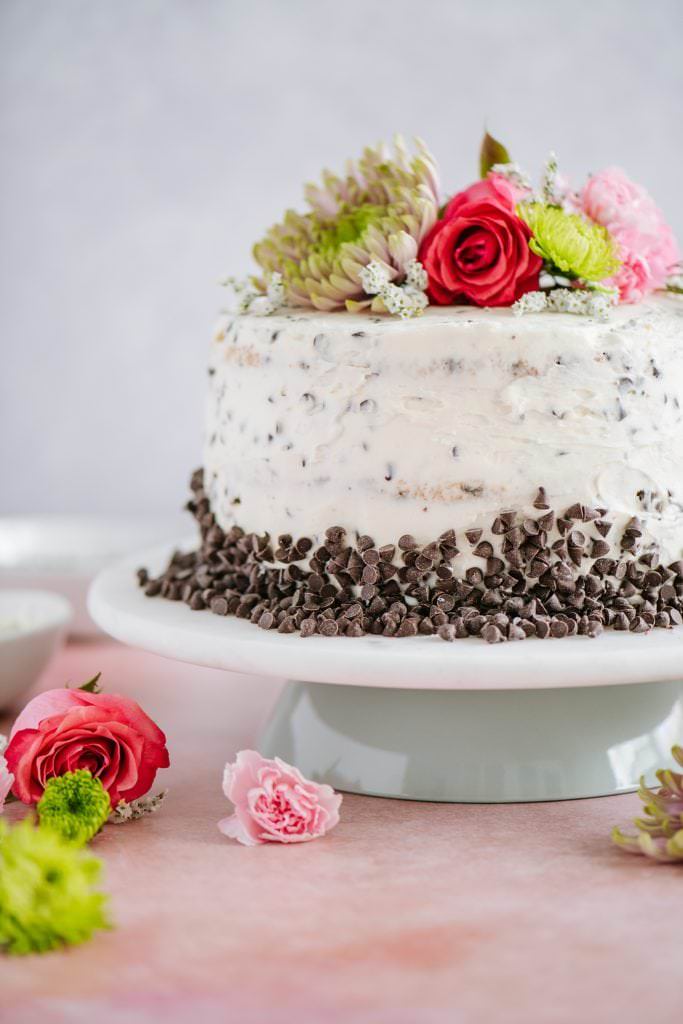 easy homemade cake with chocolate chips and buttercream frosting on cake stand