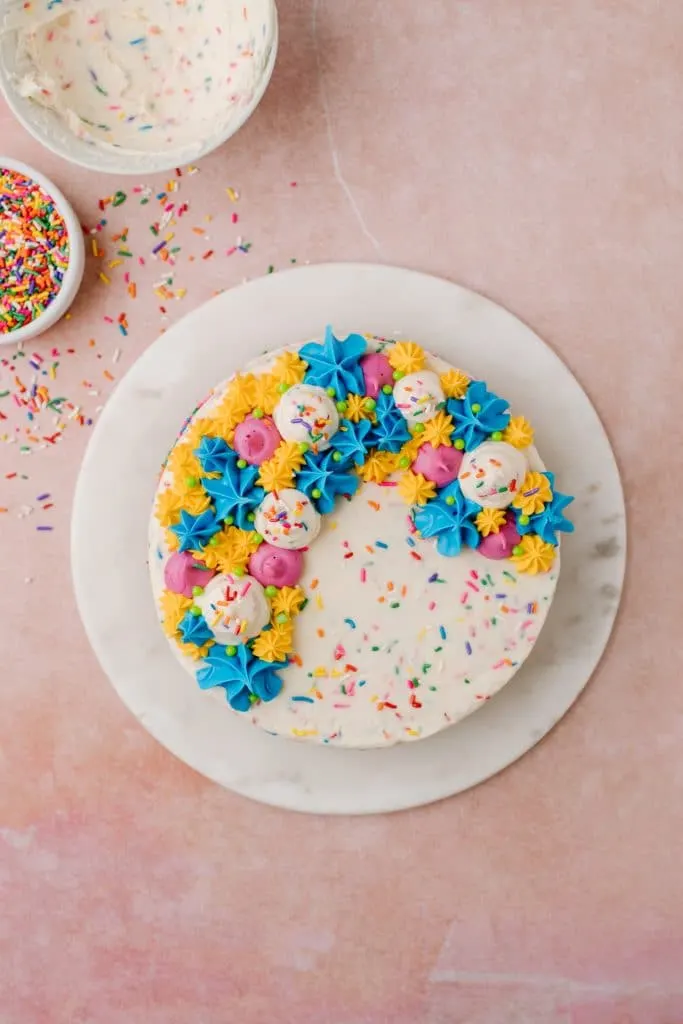 colorful and decorative funfetti cake with sprinkles on white platter