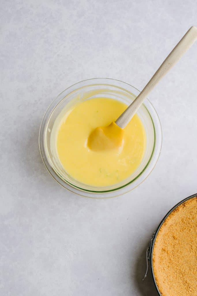 homemade lime curd filling in glass bowl with yellow spatula