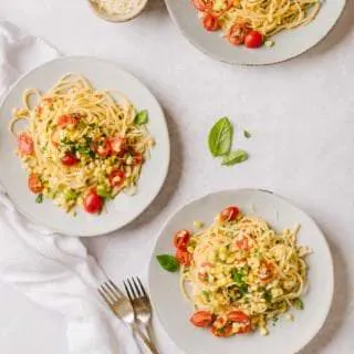 three plates of pasta with sweet corn gremolats and a small bowl of Parmesan