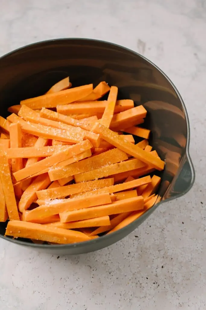 unbaked sweet potato fries in large bowl