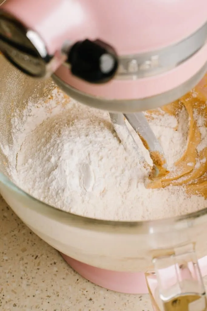 adding flour to biscoff cupcake batter in stand mixer