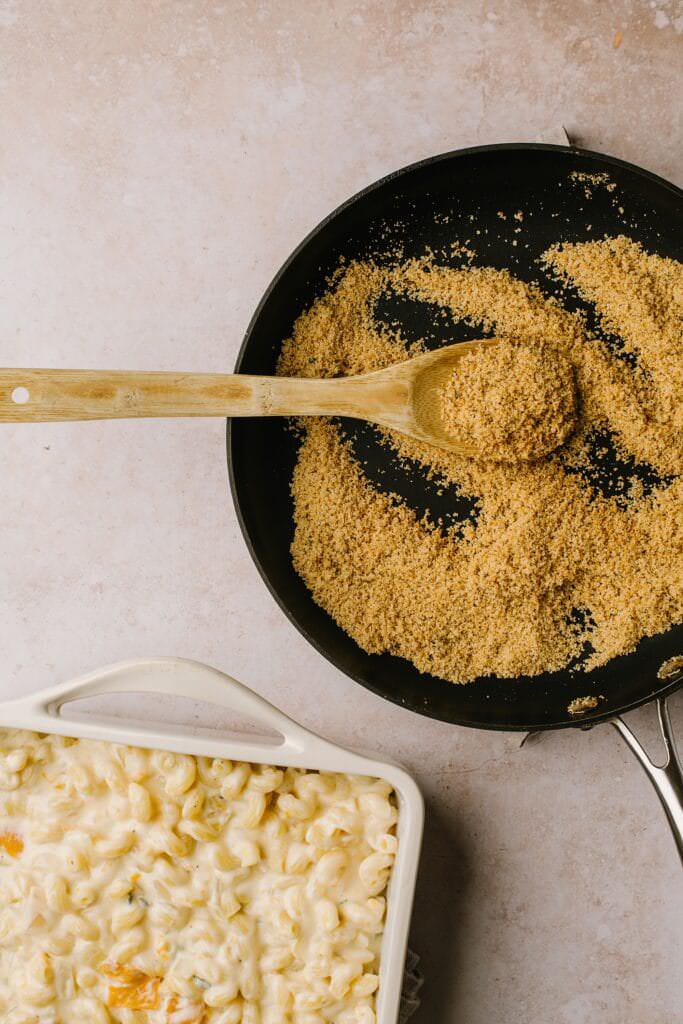 toasted breadcrumbs in skillet with wooden spoon