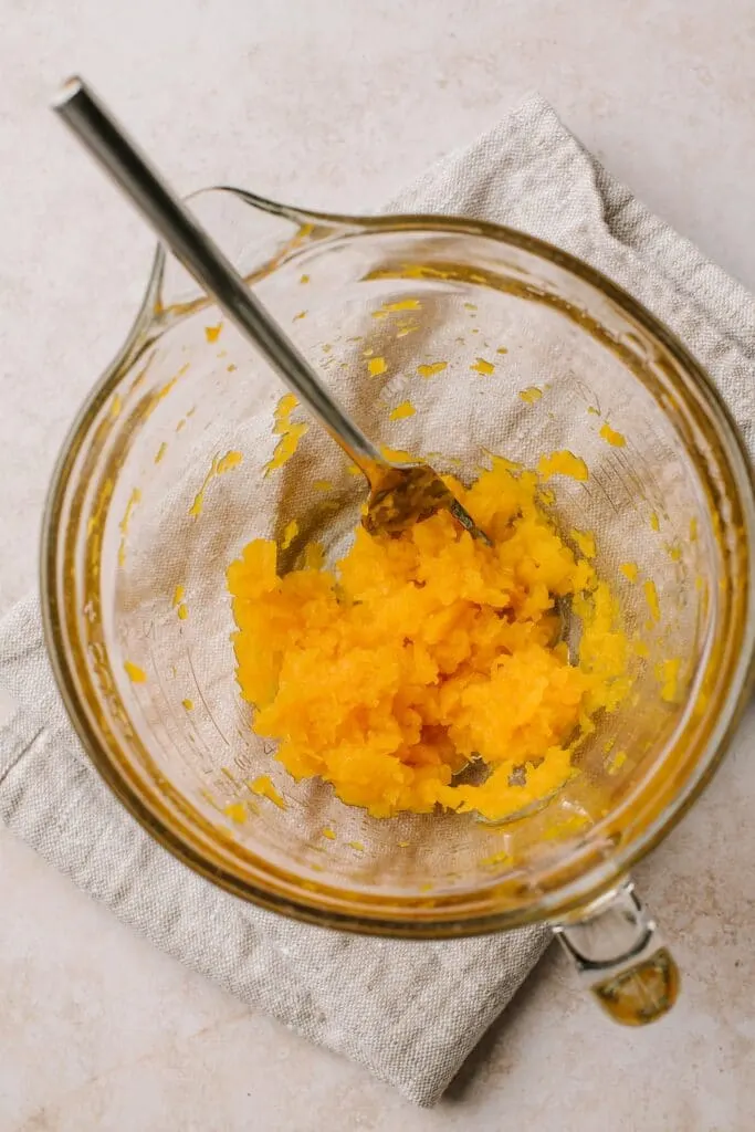 mashed butternut squash in glass bowl with fork