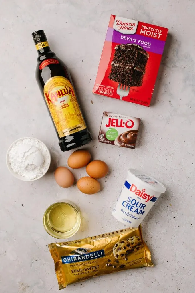 boxed cake mix, kahlua, instant chocolate pudding mix, eggs, sour cream, oil, powdered sugar, semiisweet chocolate chips