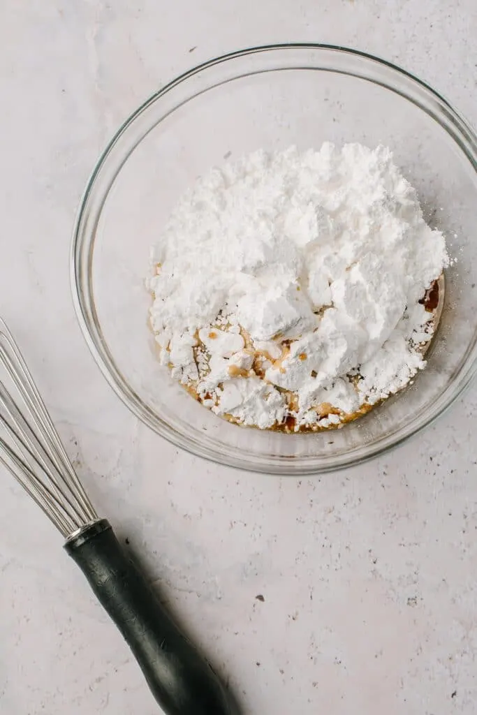 powdered sugar and kahlua in glass bowl with whisk