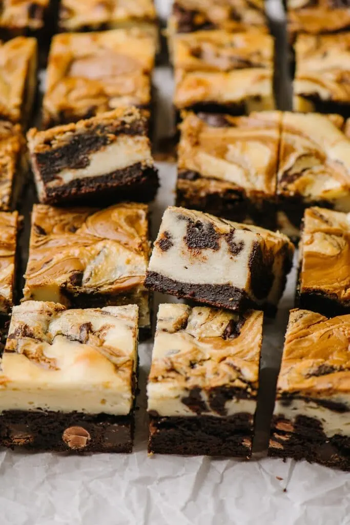 cream cheese brownie squares on parchment paper