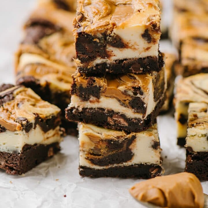stack of three cheesecake brownies with biscoff spread and squares of brownies