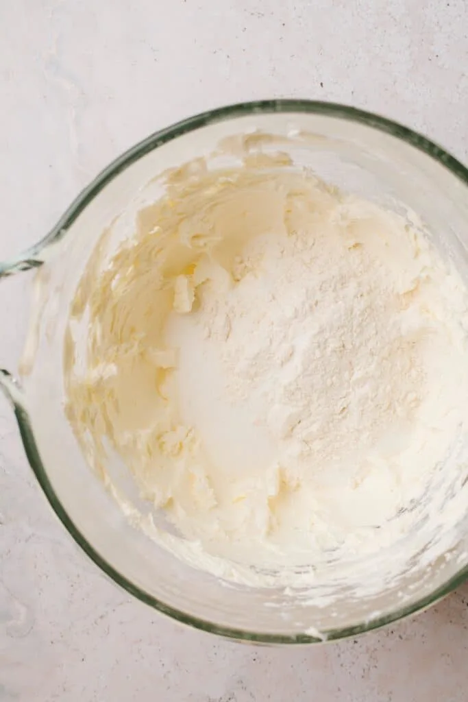 flour, sugar and whipped cream cheese in glass bowl
