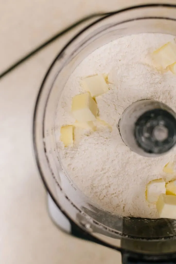 cubed butter with dry ingredients in food processor