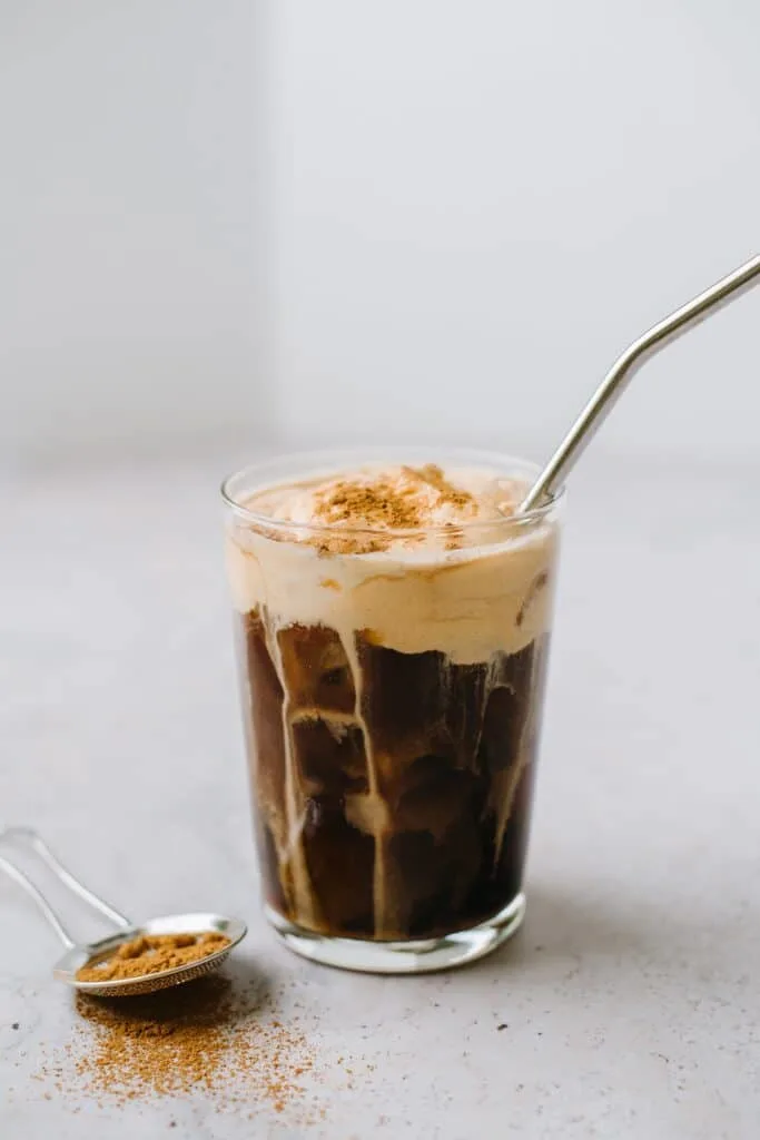 pumpkin cream cold brew in glass with metal straw
