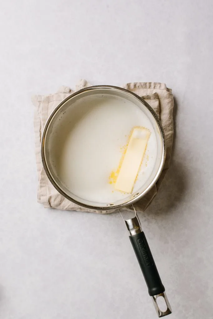 melting stick of butter with milk in pot