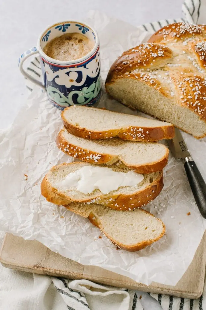 sliced cardamom bread slather with butter with cup of coffee