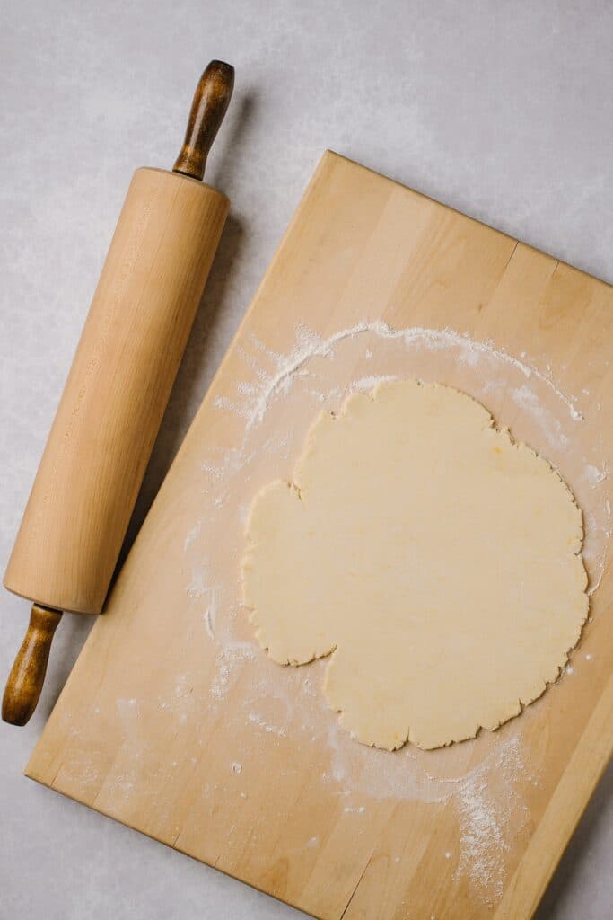 A shot from above of the rolled out rugelach dough, next to a rolling pin. 