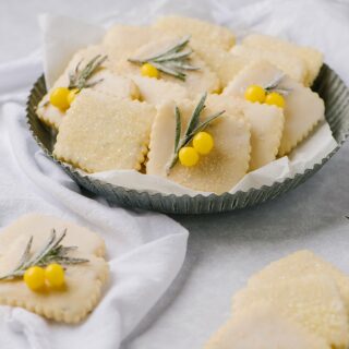 A plate of lemon rosemary cut out cookies on a plate