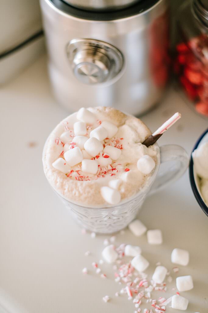 A shot from above of steamed hot chocolate, overflowing with marshmallows and peppermint candies