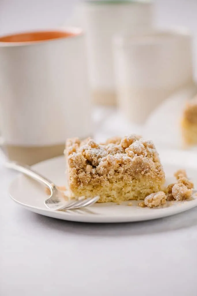 a piece of new york crumb cake on a plate with fork