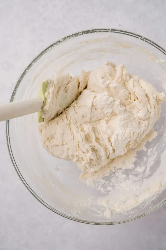 mixing flour and water together in a bowl with a spatula