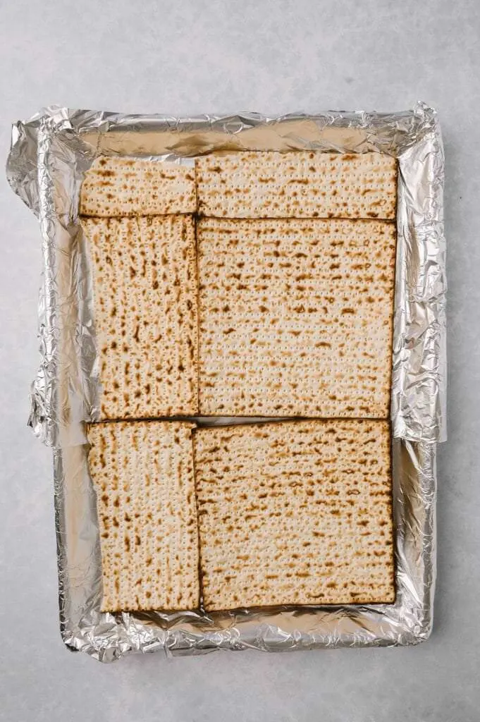 matzah laid out on a baking sheet for salted toffee matzah