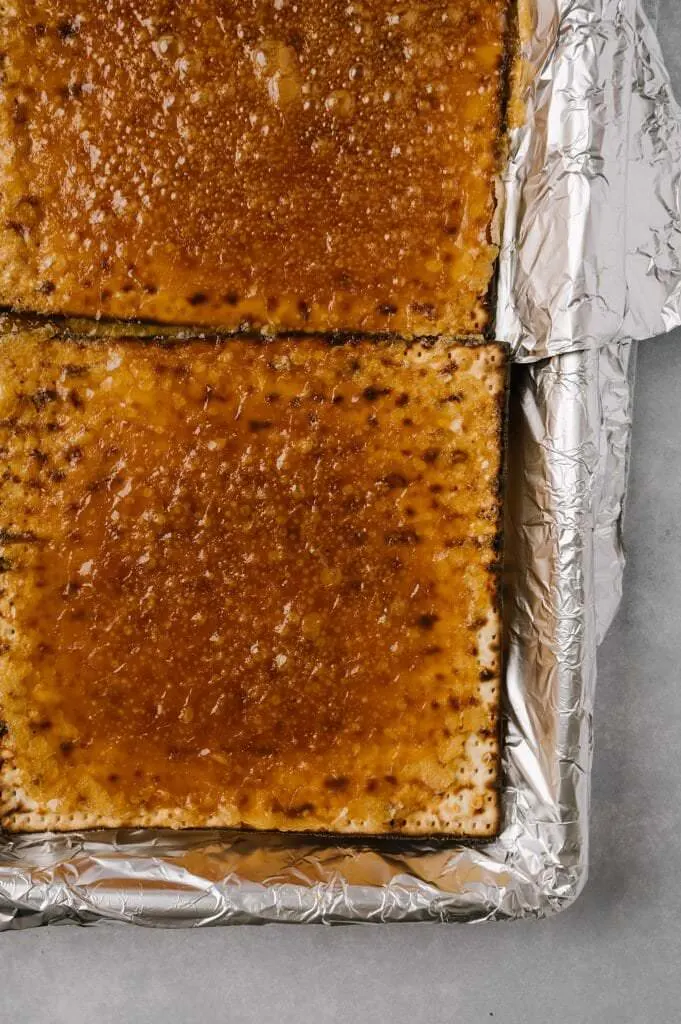 baked toffee on matzah on a foiled lined sheet pan