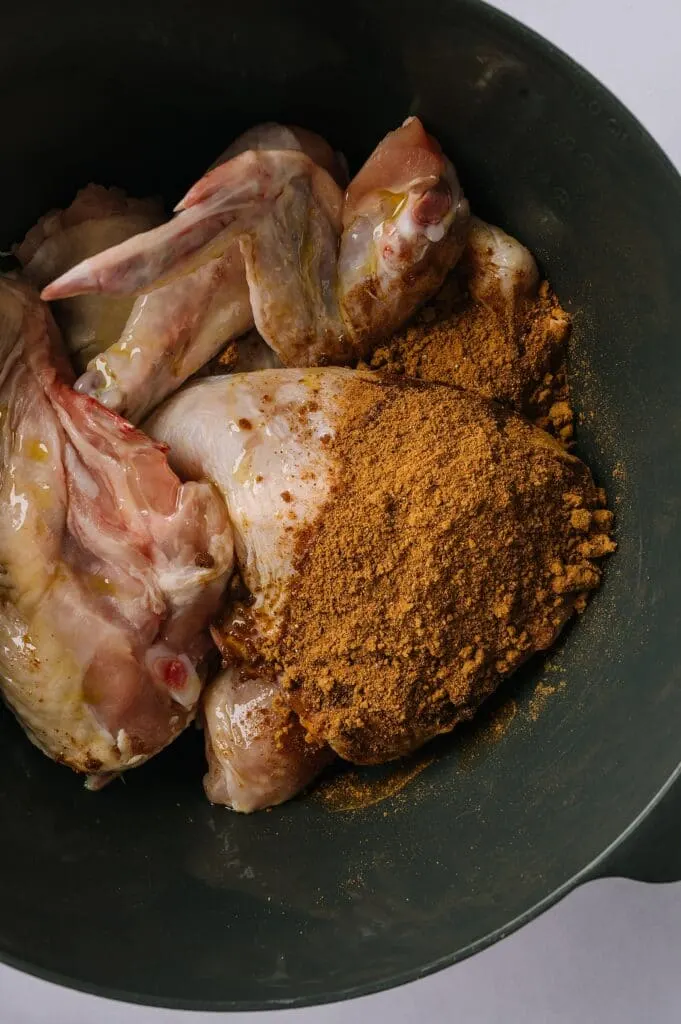 whole chicken pieces in a bowl with moroccan spice rub