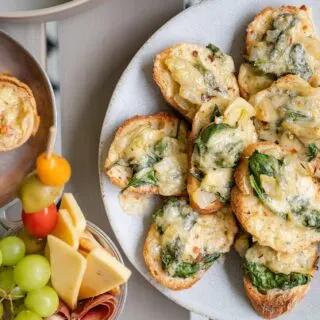 spinach and artichoke crostini on a plate