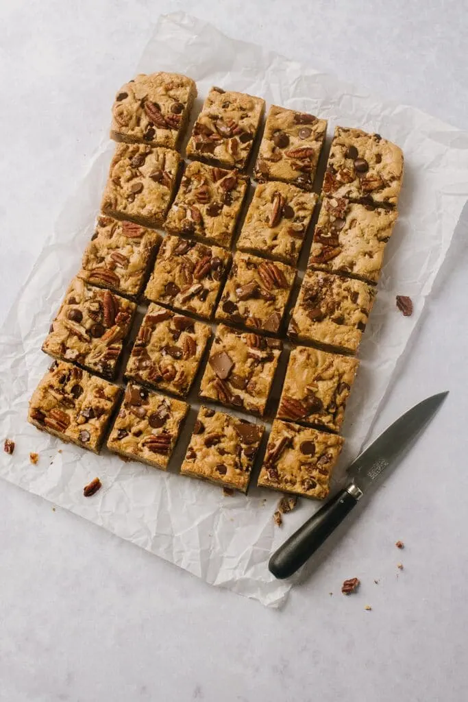 overhead shot of brown butter blondies cut into squares with a knife