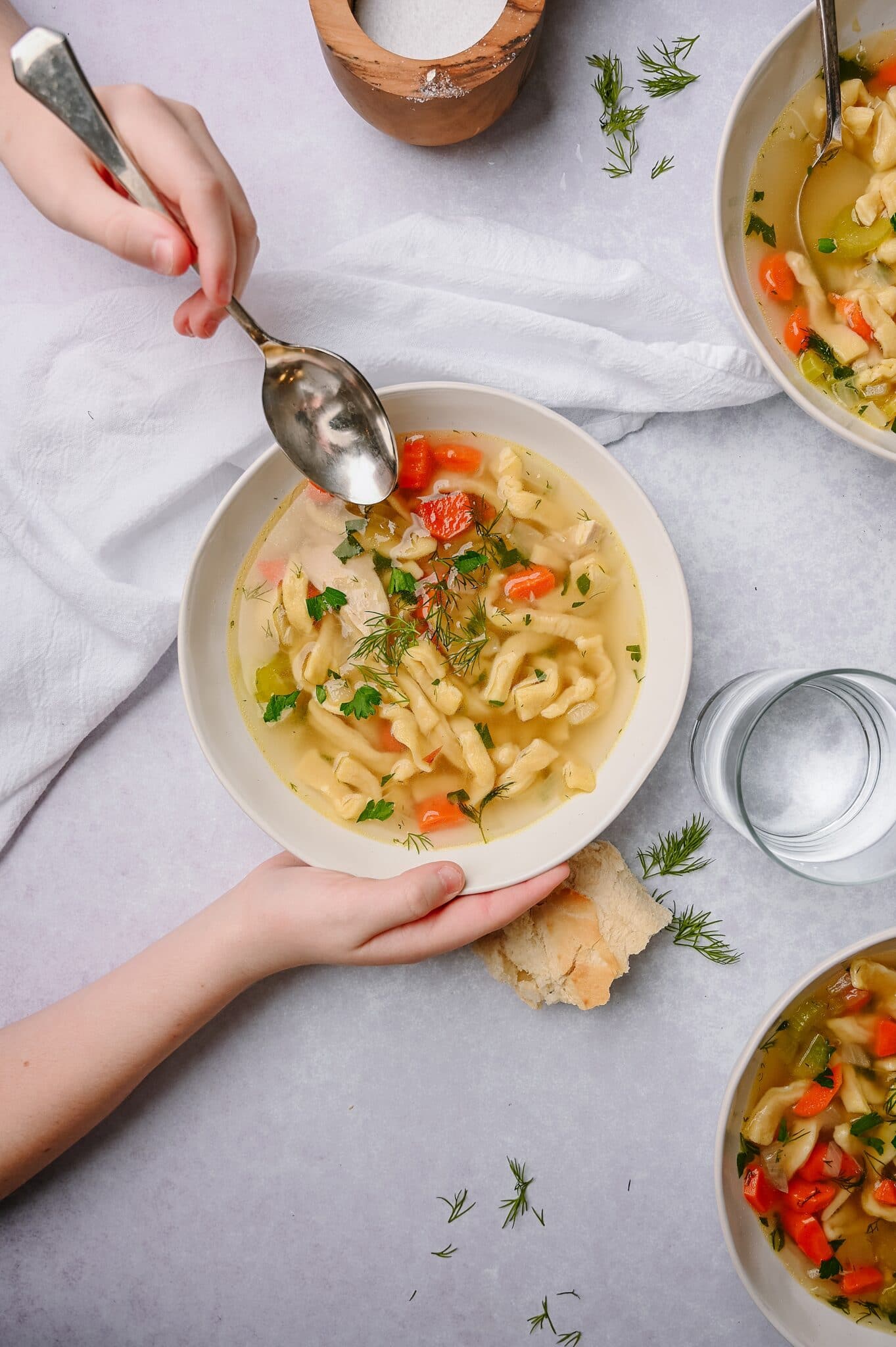 bowls of chicken soup with homemade noodles on a dinner table